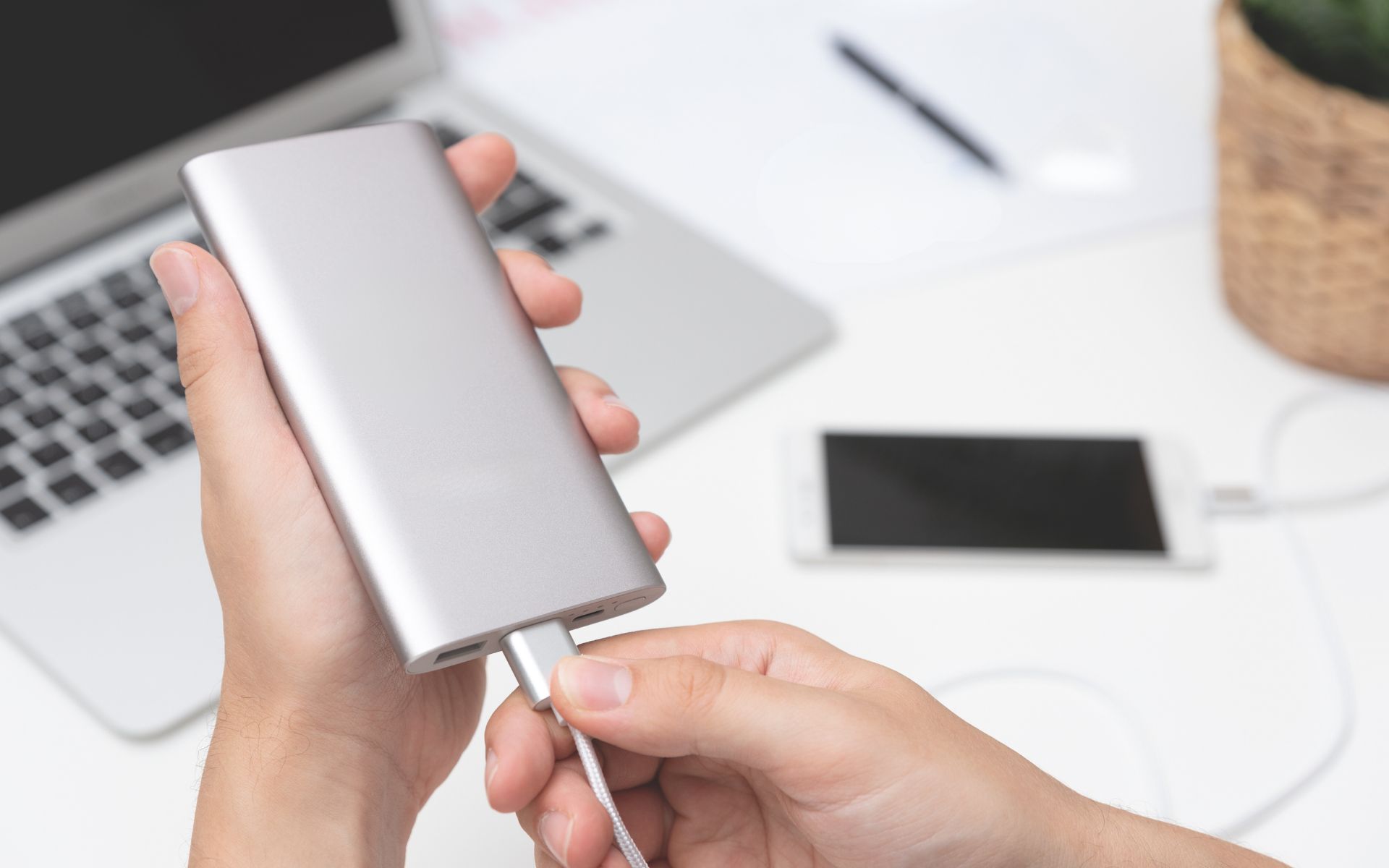 Beitragsbild für BYOD, ein Mitarbeiter schließt ein eigenes Gerät am Stromnetz des Arbeitgebers an.